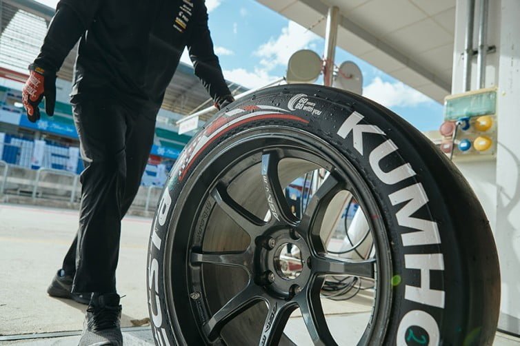 Vista de mecánico cambiando rueda de carreras de Kumho en TCR