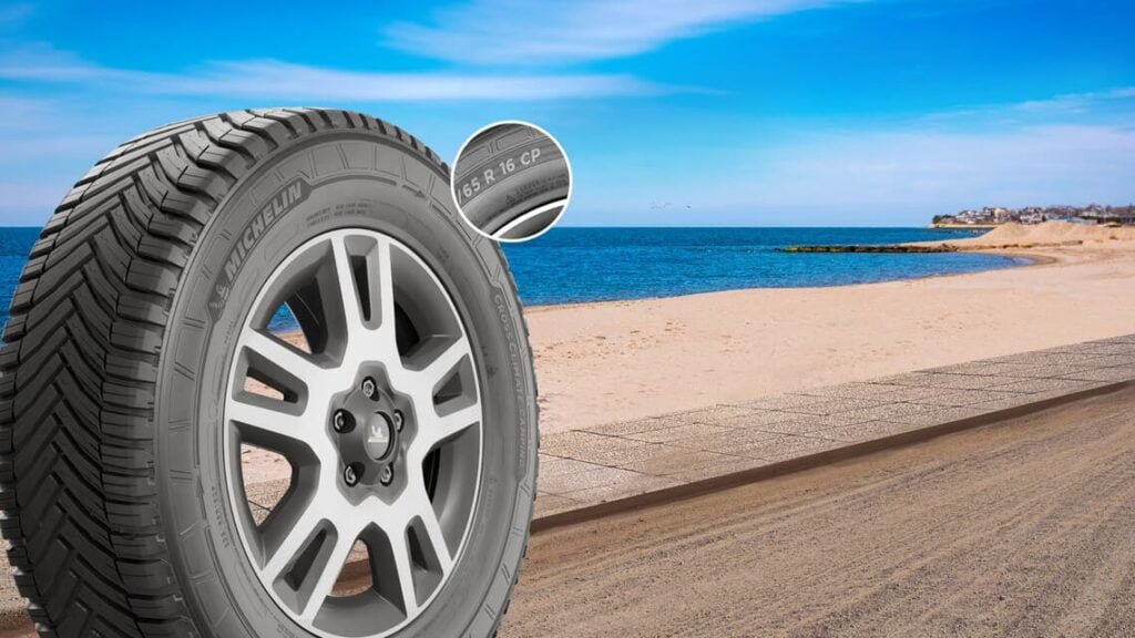 Vista de neumático Michelin CrossClimate Camping con marca CP, frente a una playa